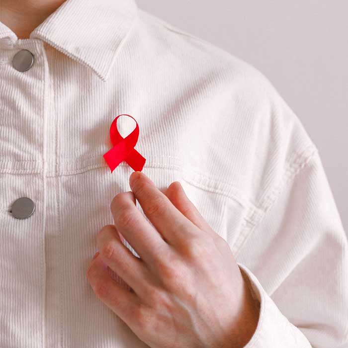 red ribbon pinned to the front of a mans shirt