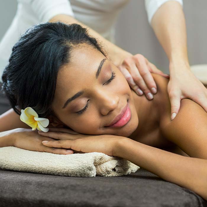 a woman enjoying a back massage at a salon