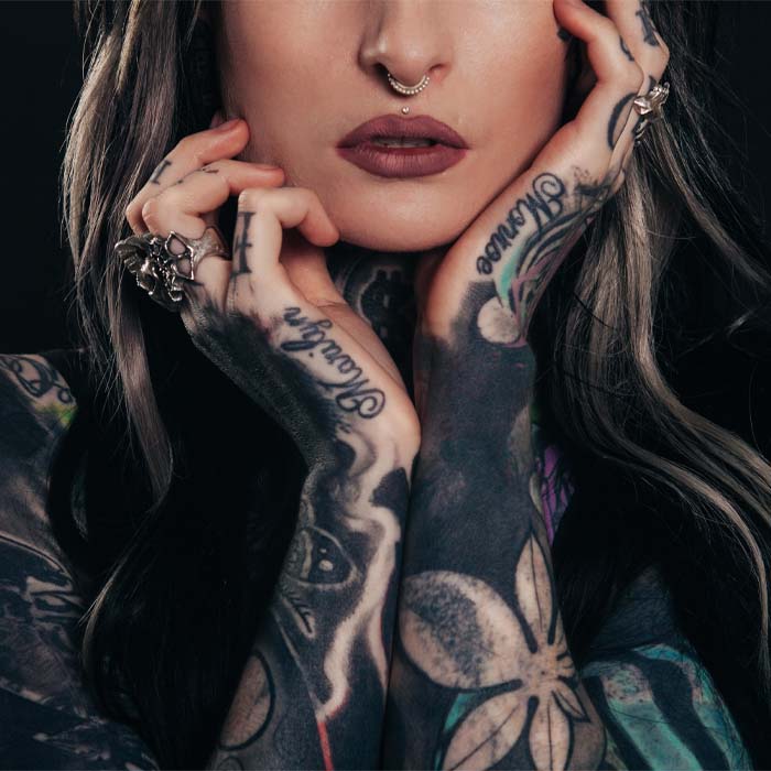 close up of a womans arms covered in tattoos