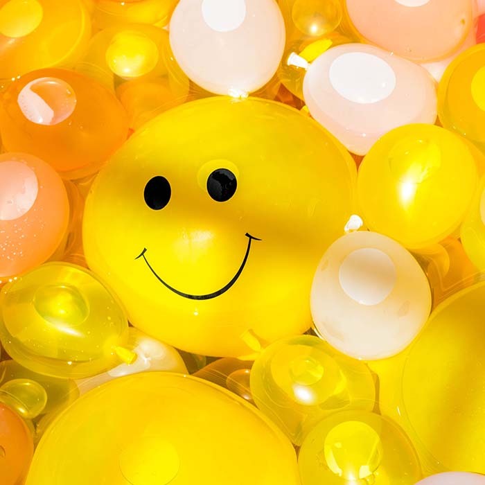 Yellow water balloons with a smiley face