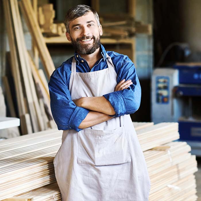 Carpenter leaning against a stack of wood